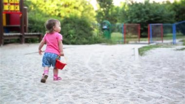 Küçük sevimli kız bebek el oyun alanında kum, kum höyükte kova ve kova ile gider de oynamak