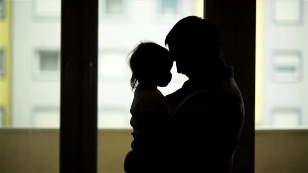 Silhouetten van vader en dochter bij zonsondergang, vader spelen met zijn kind — Stockvideo