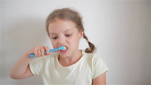 Dişlerini parlak renkli bir diş fırçasıyla fırçalayan küçük bir kız. — Stok video