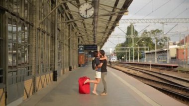 Mutlu çift tren istasyonu platformu üzerinde kucaklayan. Elveda tren istasyonu, kız ve adam platformda öpüşme, koca karısını karşılar