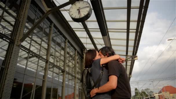 Ευτυχισμένο ζευγάρι αγκαλιάζει σε σιδηροδρομικό σταθμό πλατφόρμα. Αποχαιρετισμός στο σιδηροδρομικό σταθμό, νεαρό κορίτσι και ο τύπος φιλιά στην πλατφόρμα — Αρχείο Βίντεο