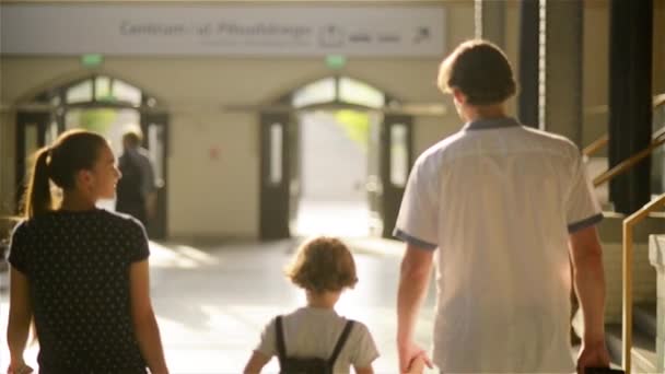 Mãe, pai, sol e filha com saco e mala vão embora na estação ferroviária — Vídeo de Stock