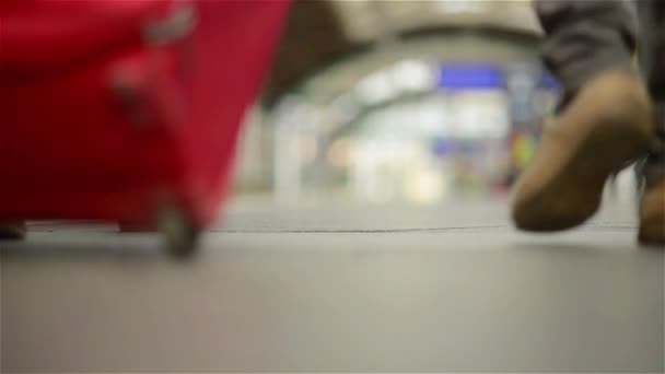 Feet walking on the platform passengers with a suitcase, young couple walking along the platform to the train with baggage — Stock Video