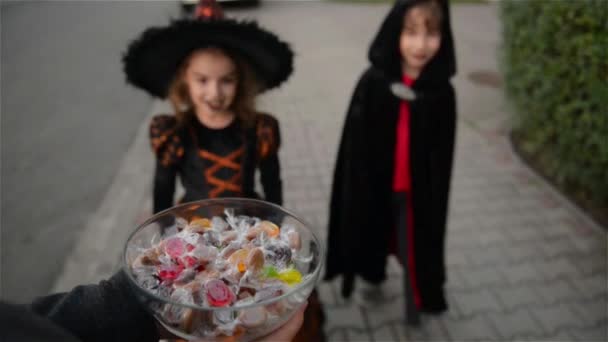 Halloween, barnen vill ha Halloween godis, barn bär häxa kostymer med hattar, barnen Bus eller godis. — Stockvideo