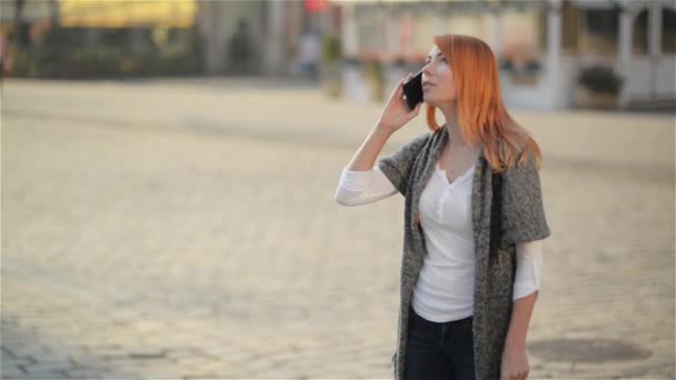 Νέοι ευτυχισμένη ενθουσιασμένος γέλιο γυναίκα μιλάμε για κινητό τηλέφωνο, κορίτσι με κόκκινα μαλλιά κύματα το χέρι της στο δρόμο, πόλη αστικό φόντο. — Αρχείο Βίντεο