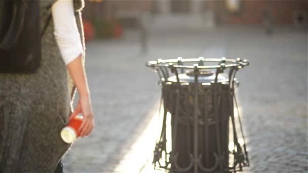 Mulher jogando copo de café de papel vazio perto de reciclagem bin, fundo da cidade. Reciclagem, conceito de abordagem ecológica. Mantenha as ruas, cidade, terra limpa — Vídeo de Stock