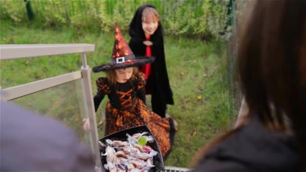 Halloween, los niños quieren dulces de Halloween, los niños que usan disfraces de brujas con sombreros, los niños engañan o tratan . — Vídeos de Stock