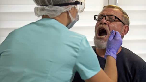 Laboratorietekniker tar äldre patienter smutskastning för att testa för coronavirus. — Stockvideo