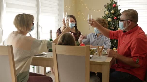 Η οικογένεια γιορτάζει Χριστούγεννα φορώντας προστατευτικές μάσκες. Όλοι συγχαίρουν ο ένας τον άλλον και πετάνε τις ενοχλητικές μάσκες. COVID-19 τρόπος ζωής. — Αρχείο Βίντεο