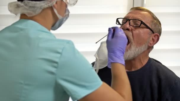 Τεχνικός εργαστηρίου παίρνει ηλικιωμένους ασθενείς κηλίδα για να εξετάσει για coronavirus. — Αρχείο Βίντεο