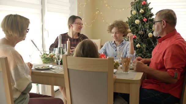 Şenlik masasında neşeli bir sohbet. Noel 'i birlikte kutlayan mutlu bir aile. Geleneksel bayram yemeği çok nesilli ailede. — Stok video