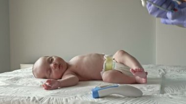 Klinikte temassız termometreyle yeni doğmuş bir bebeğin sıcaklığını ölçmek..