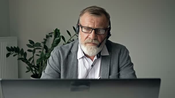 Un employé âgé parler parler engagé dans une conférence en ligne à l'aide d'un gadget informatique. Concept de communication. — Video