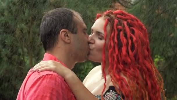 Pasangan yang jatuh cinta dengan penuh gairah berciuman di tengah hujan musim panas. — Stok Video