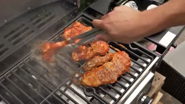 Mão de homem grelhando um pouco de carne na grelha. — Vídeo de Stock