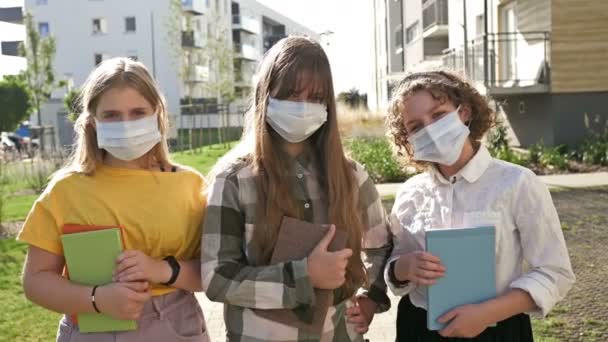 Grupo de colegialas con máscaras médicas para protegerse contra el coronavirus. Regreso a la escuela. — Vídeos de Stock