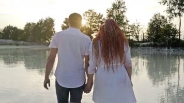 Gün batımında iki aşık el ele tutuşarak göle gider. Romantik randevu.