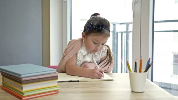 Маленькая школьница делает домашнее задание. Милый ребенок учится самостоятельно. Возвращение в школу. — стоковое видео