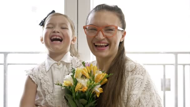 Retrato de una joven y su hijita con un ramo de freesias. Humor festivo. — Vídeos de Stock