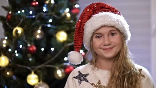 Portré boldog tizenéves lány mosolygós boldog tini élvezi ünnepi ünnep ünneplés otthon, karácsonyfa a háttérben — Stock videók