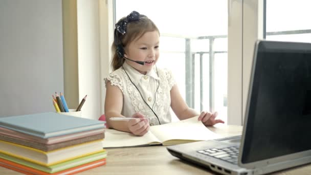 लहान मुलगी इंटरनेटद्वारे शिक्षकाशी संवाद साधते. विलगीकरणादरम्यान ऑनलाइन प्रशिक्षण . — स्टॉक व्हिडिओ