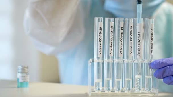 Hentikan pandemi. Seorang ahli bekerja pada 19 vaksin coronavirus di laboratorium yang bersih mengenakan pakaian pelindung, sarung tangan, kacamata dan masker. — Stok Video