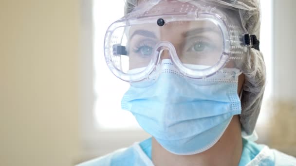 Egy fáradt orvos portréja. A nő leveszi a szemüvegét, maszkot visel, és megkönnyebbülve sóhajt. Közelkép. — Stock videók