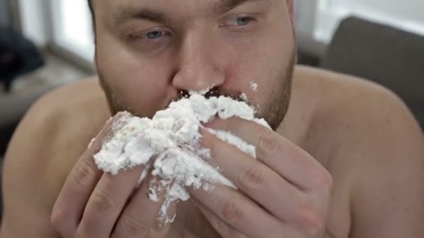 クリームでケーキを貪欲に食べる中年男性の肖像画。甘い食べ物の恋人. — ストック動画