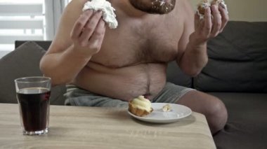 Şişman orta yaşlı adam açgözlülükle kremalı pasta yiyor. Zararlı yeme alışkanlıkları.