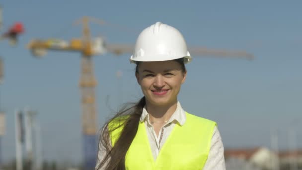 Dziewczyna budowniczy w odzieży ochronnej na placu budowy. — Wideo stockowe