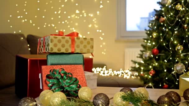 クリスマスツリーの背景にあるテーブルの上の多くのクリスマスプレゼント. — ストック動画
