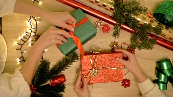 Hände zweier Frauen, die sorgfältig Weihnachtsgeschenke verpacken. Weihnachtstag. — Stockvideo