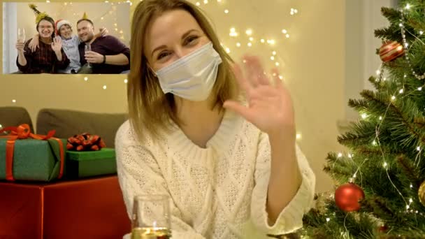 Kvinna, isolerad under karantänsperioden, önskar sina vänner God Jul via Internet. Semester mitt i COVID-19-pandemin. — Stockvideo