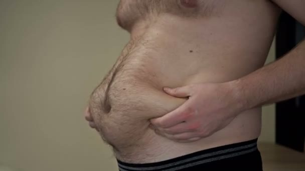 豊満な男は腹に余分な脂肪の折り目を示しています。過重量問題. — ストック動画