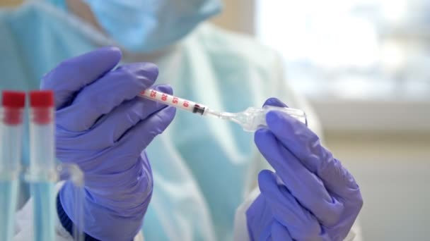 Dokter atau perawat mengisi jarum suntik dengan vaksin. Vaksinasi massal dimulai. Hentikan pandemi COVID-19. — Stok Video
