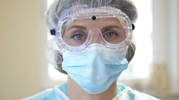 Το πορτρέτο ενός κουρασμένου γιατρού. Η γυναίκα βγάζει τα γυαλιά και τη μάσκα της και αναστενάζει με ανακούφιση. Κοντινό πλάνο. — Αρχείο Βίντεο
