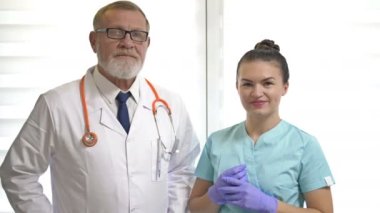 Yaşlı bir erkek doktor ve genç bir kadın hemşire portresi. Profesyonel ikili..