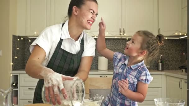 Kleine Tochter hilft ihrer Mutter beim Teigkochen. Spaß und lohnende Familienzeit. — Stockvideo