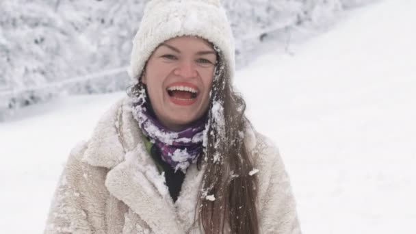 Porträtt av en glad ung kvinna efter en kamp med snöbollar. — Stockvideo