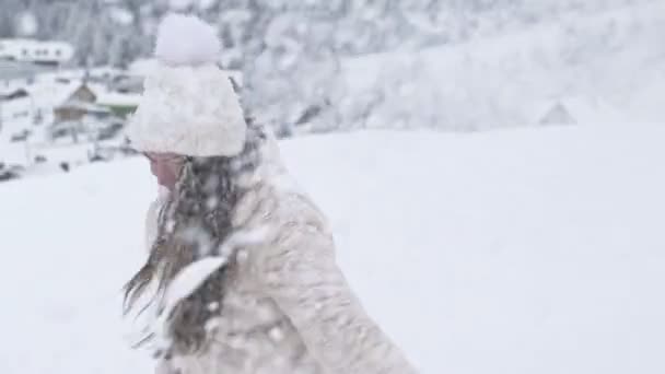 Wanita cantik muda berputar, dan seseorang menaburkan salju padanya. Musim dingin menyenangkan. — Stok Video