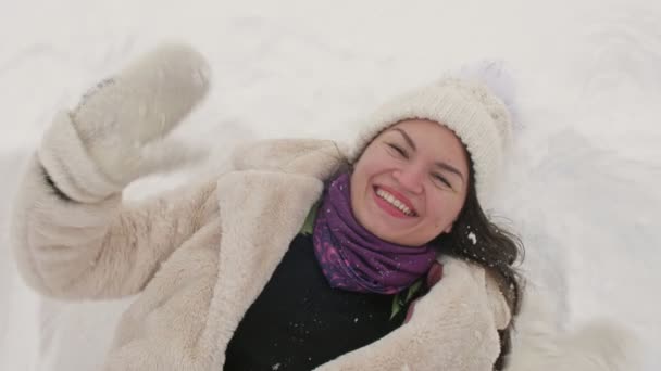 Jovem mulher está na neve e ri alegremente. — Vídeo de Stock