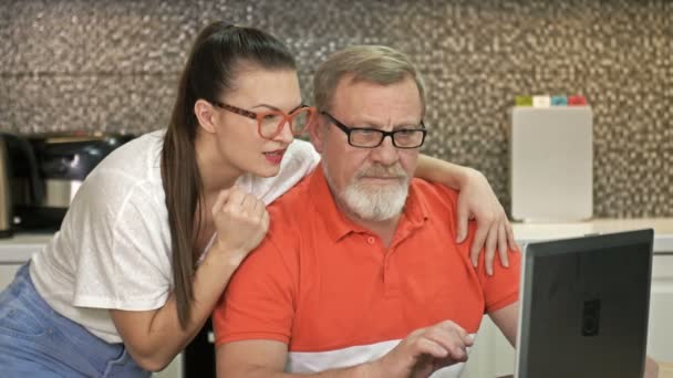 Roztomilá brunetka a její otec upřeně zírají na monitor notebooku. Dobrá zpráva je, že způsobují bouři pozitivních emocí.. — Stock video