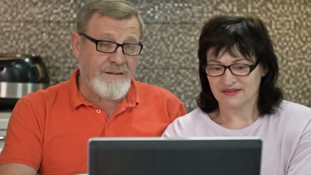 Pár senior pomocí notebooku doma pro online nakupování, surfování na internetu. — Stock video