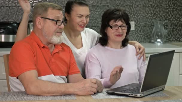 Ett äldre par och deras vuxna dotter kommunicerar med någon via Internet. Modern teknik, nya möjligheter. — Stockvideo