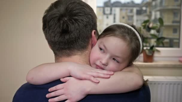 Egy 6-7 éves lány gyengéden megöleli az apját. Az apaság öröme. — Stock videók