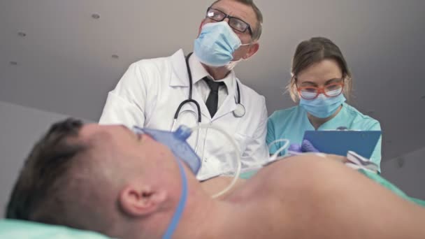 Artsen van de Spoedeisende Hulp verlenen hulp aan een patiënt tijdens een ernstige aanval van ziekte. — Stockvideo