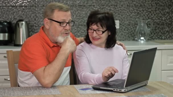 Freundliches Ehepaar nutzt Laptop zu Hause für Online-Einkäufe. Einkaufen während der Coronavirus-Pandemie. — Stockvideo