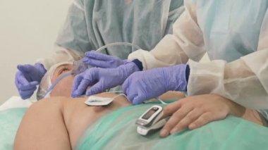 Doktorlar erkek bir hastayı tıbbi muayene için hazırlıyorlar..