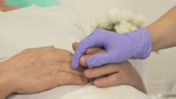 Gros plan. Les médecins mains tenant la main d'un patient âgé. geste de soutien. — Video