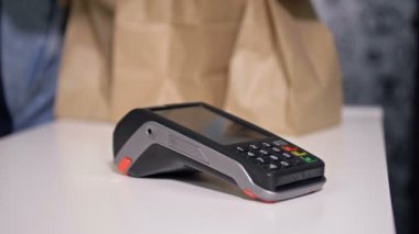 Alıcı kahvenin parasını telefonla ödüyor. Temassız ödemeler.